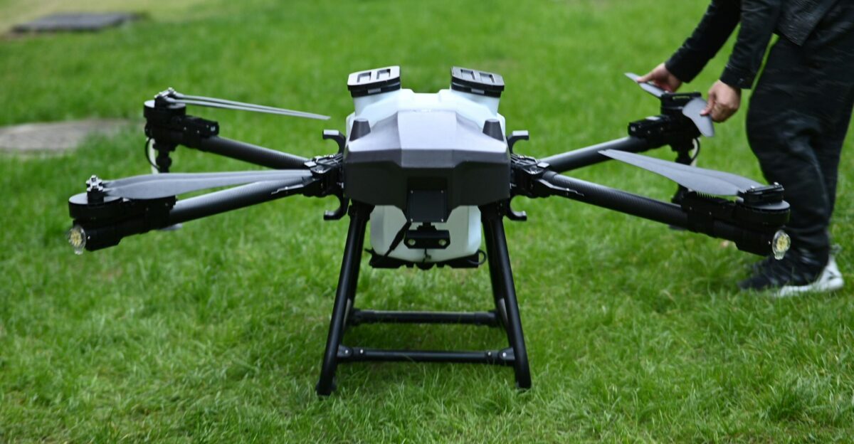 A man standing next to a black and white flying device