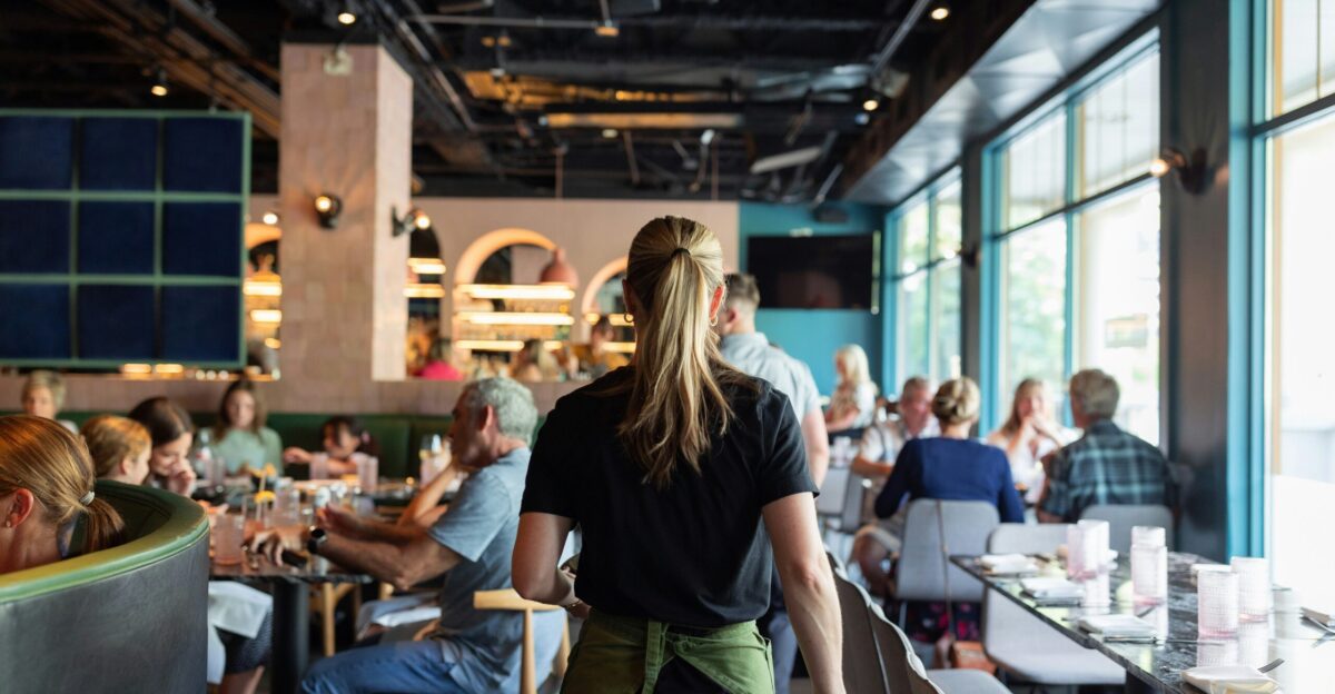 A group of people sitting at tables in a restaurant