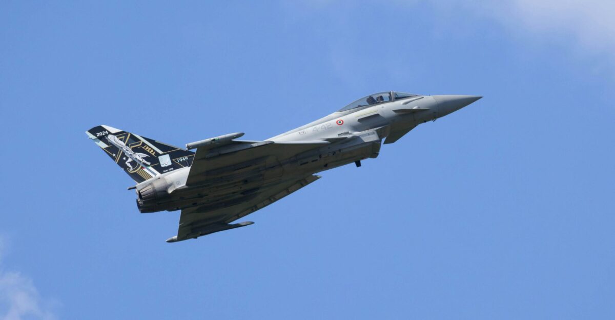 A fighter jet flying through a blue sky