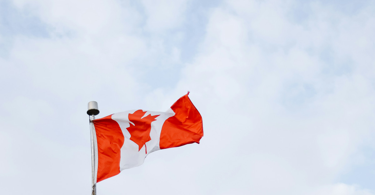 Two red flags flying in the wind on a cloudy day