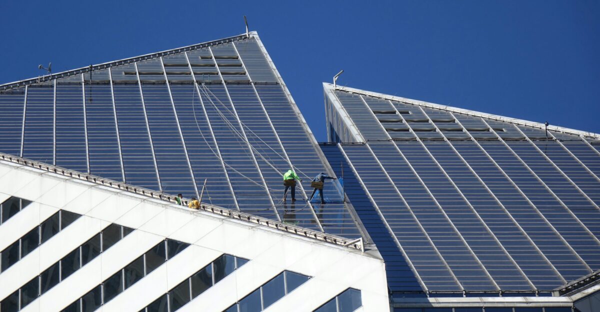 A man on a ladder working on the roof of a building