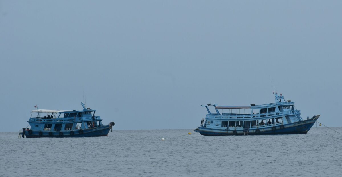 A group of boats floating on top of a large body of water