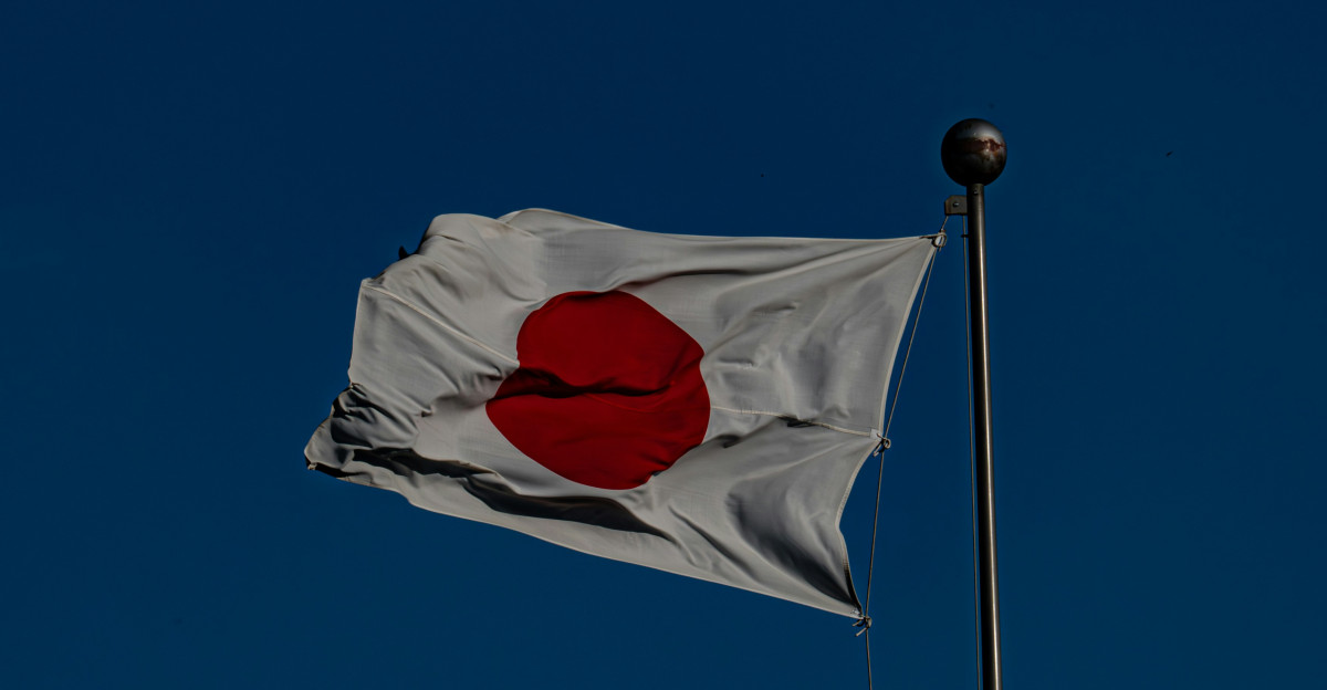 A flag flying in the wind with a blue sky in the background
