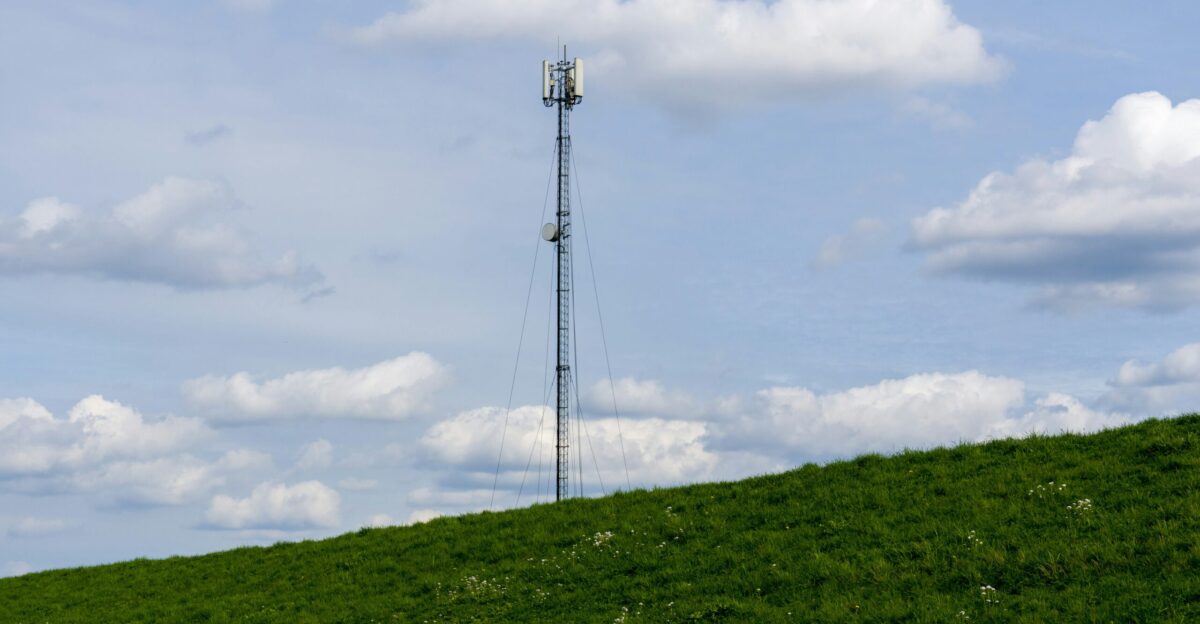 A cell phone tower on a grassy hill