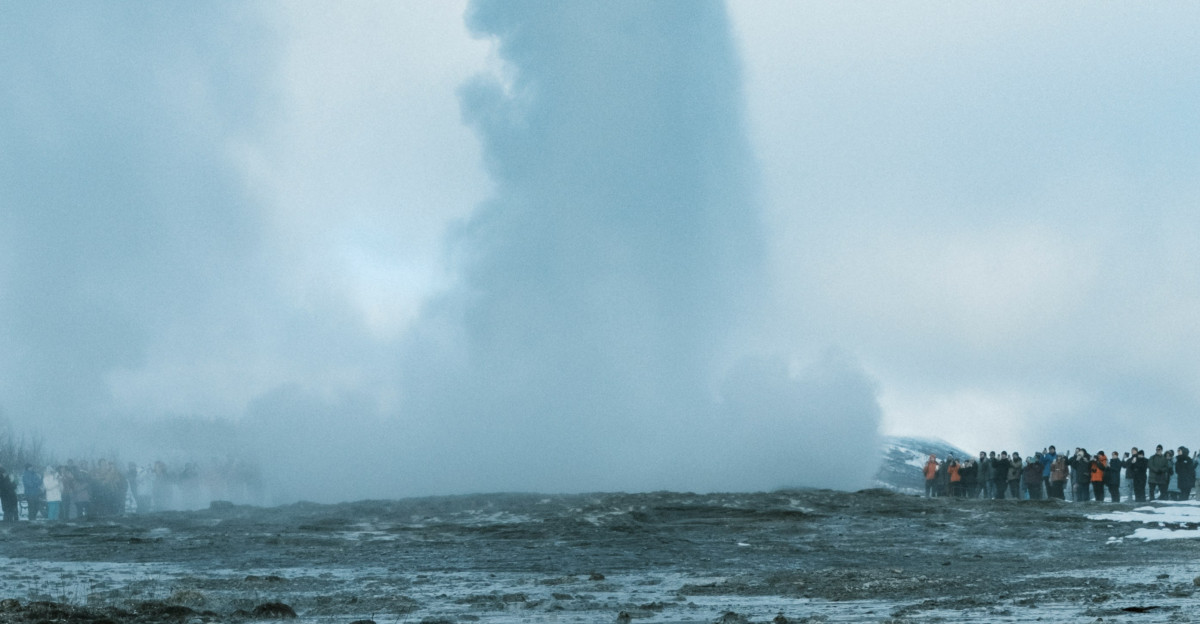 A geyser erupts impressing many onlookers
