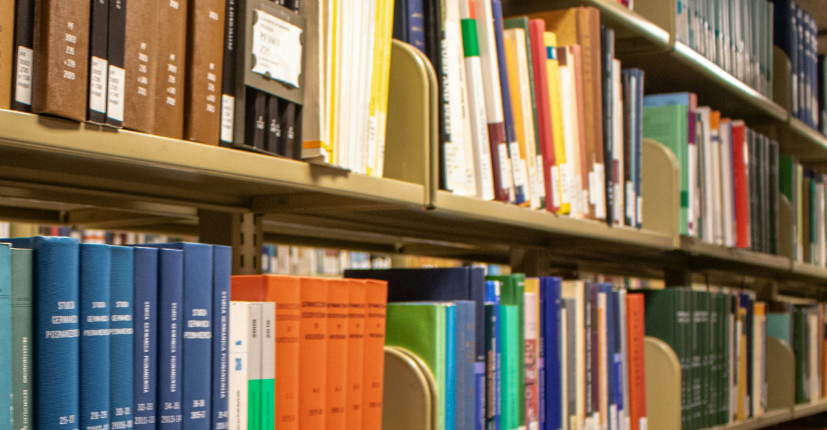 Bookshelves are filled with colorful books in a library