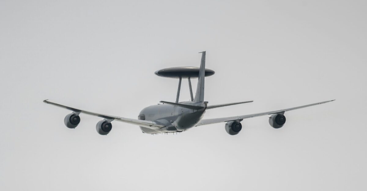 Awacs aircraft flying through a cloudy sky