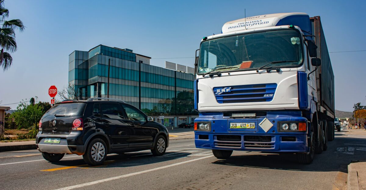 A truck and car share a sunny road