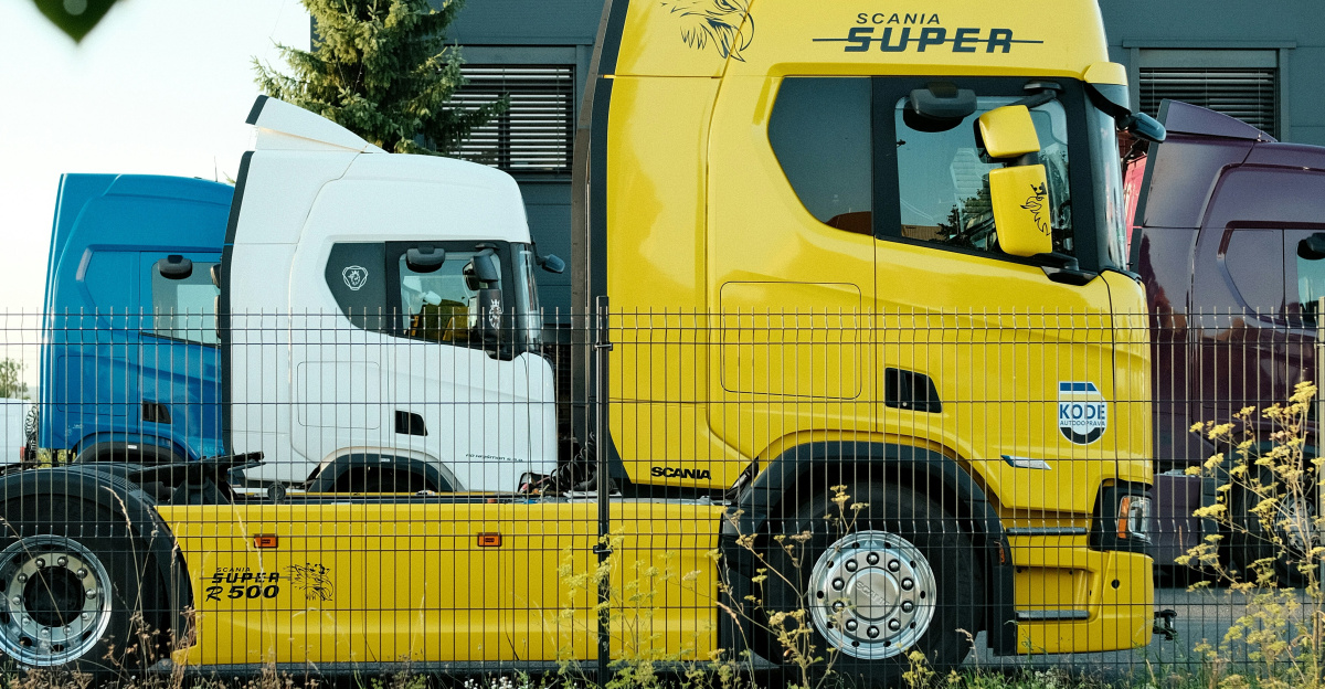 Two scania trucks parked outside a building