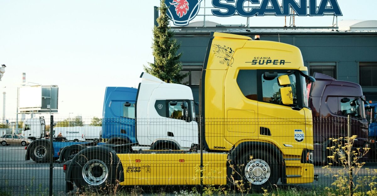 Yellow and blue trucks parked outside scania building