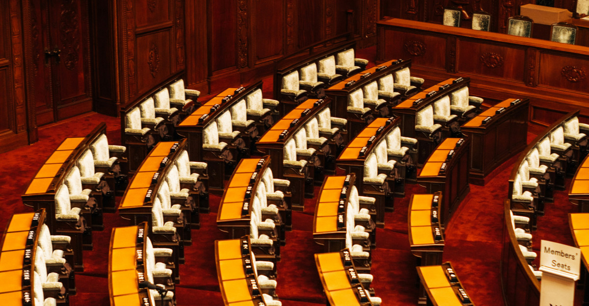 Empty parliamentary chamber with rows of seating