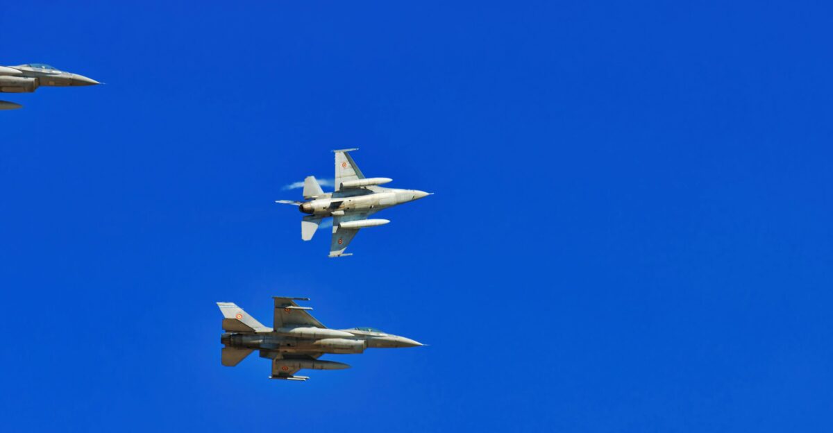 Three fighter jets flying in formation against a blue sky