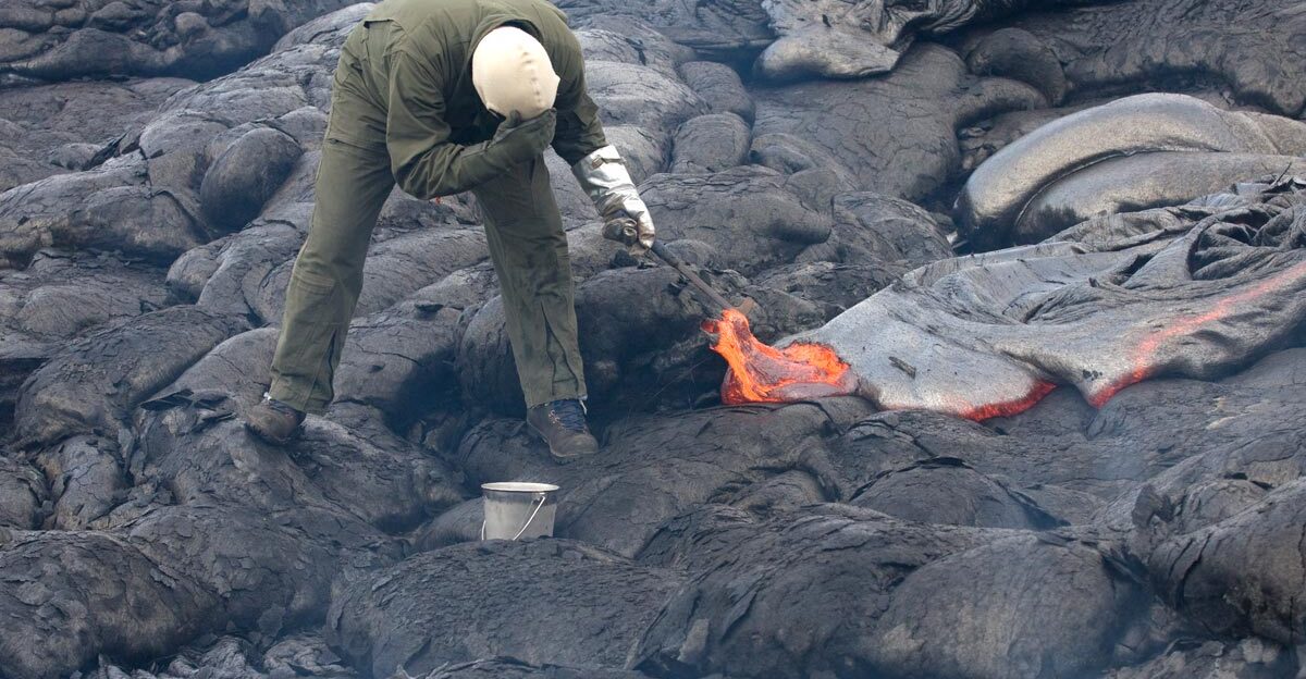 A geologist collecting a lava sample for chemical analyses from an active lava flow on Kilauea using a rock hammer and a bucket of water