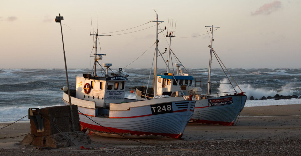 Two beached fishing vessels at sunset at N rre Vorup r Denmark