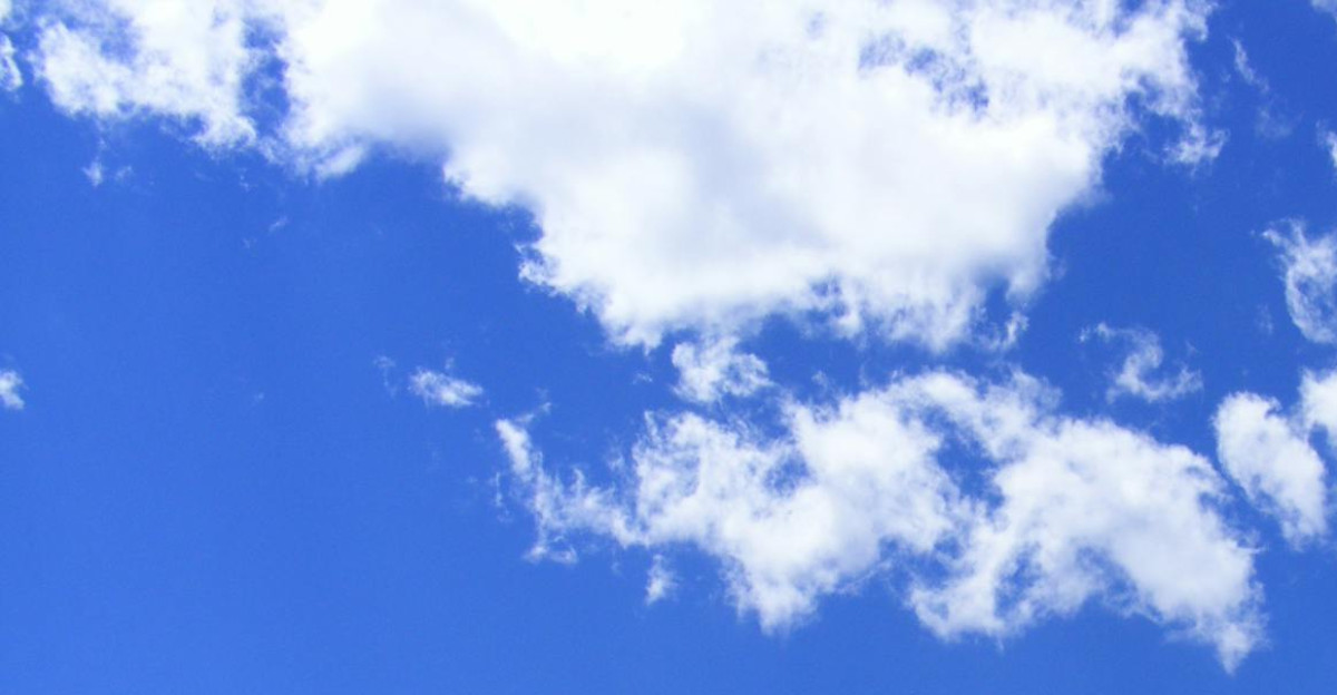 Vibrant cumulus clouds adorn a clear blue sky creating a serene and dreamy cloudscape