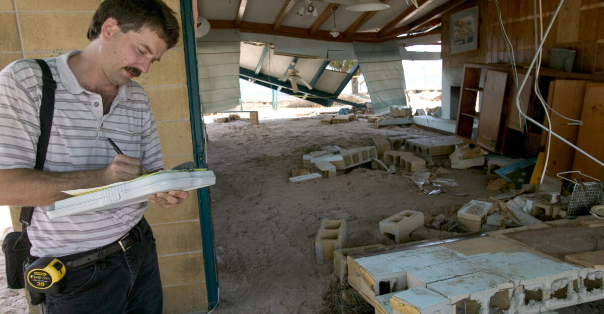 Shell Pt FL 7 18 2005-Insurance adjuster Mike McConaghy reviews remains of home at Shell Point following Hurricane Dennis FEMA photo Andrea Booher