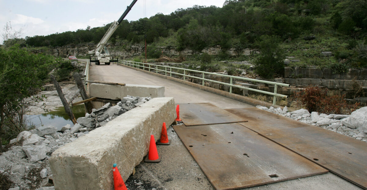 Marble Falls TX July 2 2007 - Workers clear debris from a local creek and work on a damaged bridge after last week s record rainfall of 19 inches in one night Bob McMillan FEMA Photo