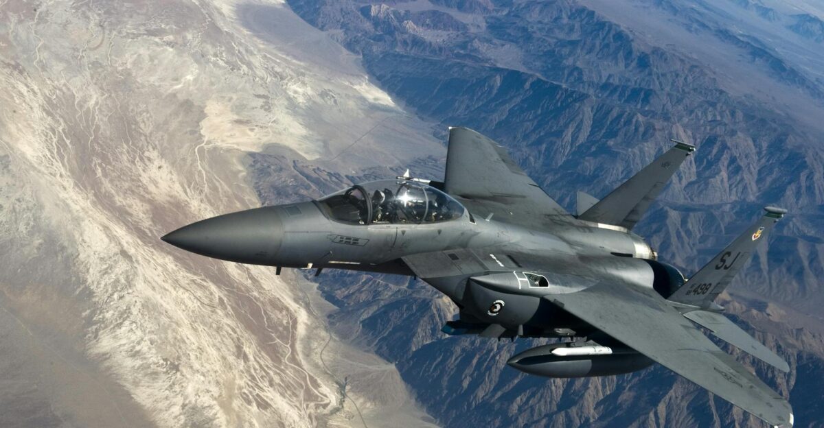 A military fighter jet flying above rugged mountain ranges showcasing advanced aviation technology