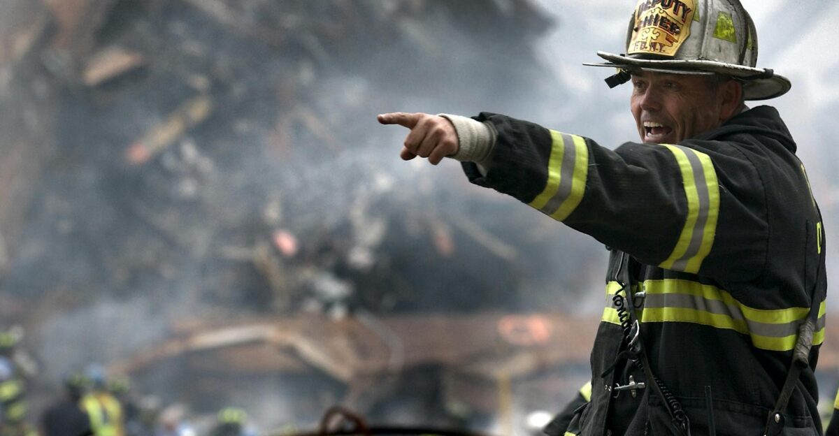 A firefighter in action at a disaster scene directing rescue operations amidst smoke and debris