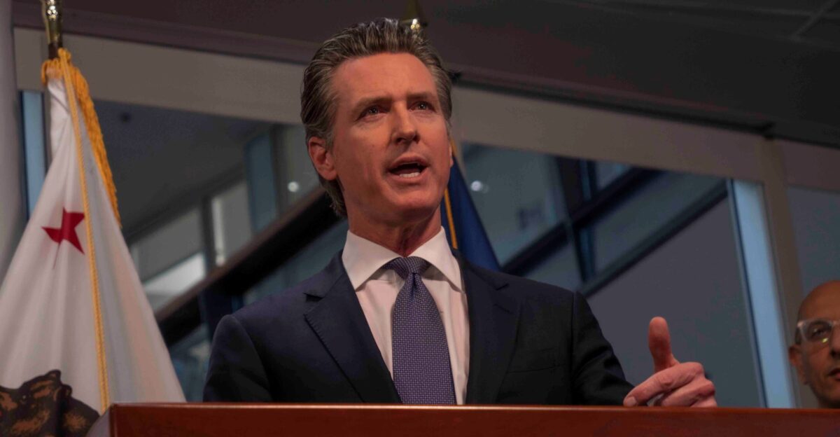 Gavin Newsom speaking at a podium in Sacramento