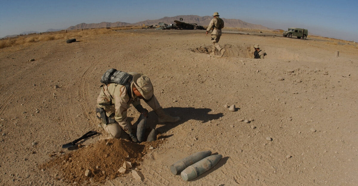 Kandahar Afghanistan Dec 23 2001 - U S Navy lieutenant Mike Runkle of Virginia Beach Va assigned to Explosive Ordnance Disposal Mobile Unit Two Detachment-18 prepares charges to blow up stockpiled ordnance left behind by fleeing Al Qaida troops Lieutenant Runkle leads the Joint Explosive Ordnance Disposal Detachment at a forward operating base in Kandahar Afghanistan U S Navy EOD personnel are conducting missions in support of Operation Enduring Freedom