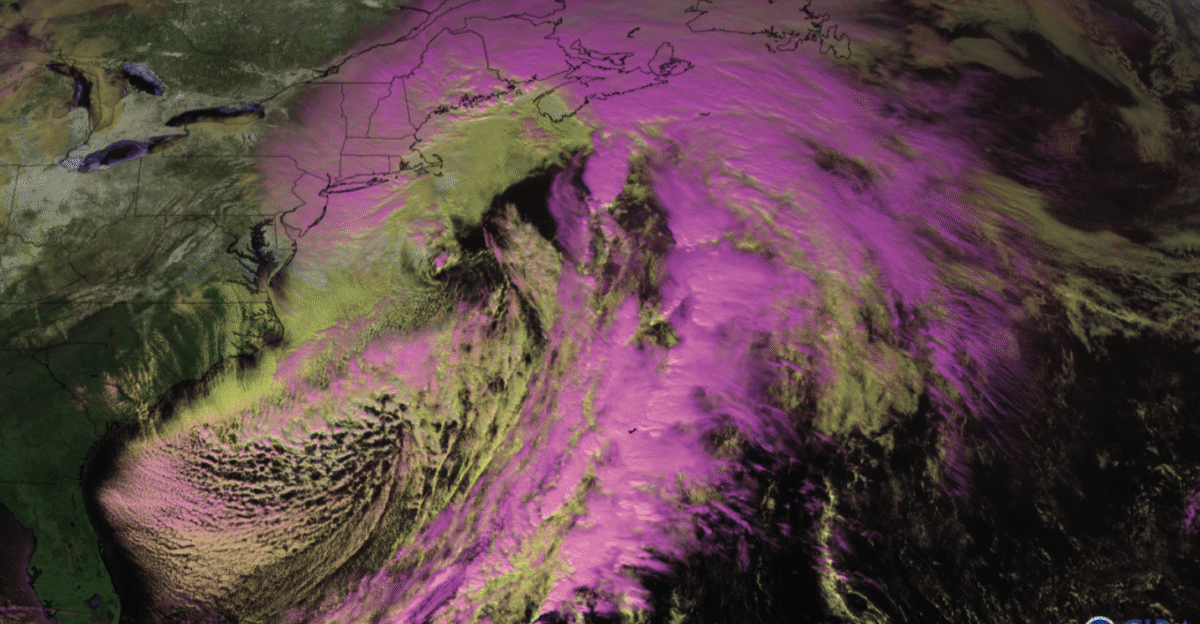 A NOAA GOES-16 satellite snow cloud composite image of a powerful nor easter pounding the eastern United States with snow on the ground appearing as white low clouds as pale yellow and high clouds as light pink