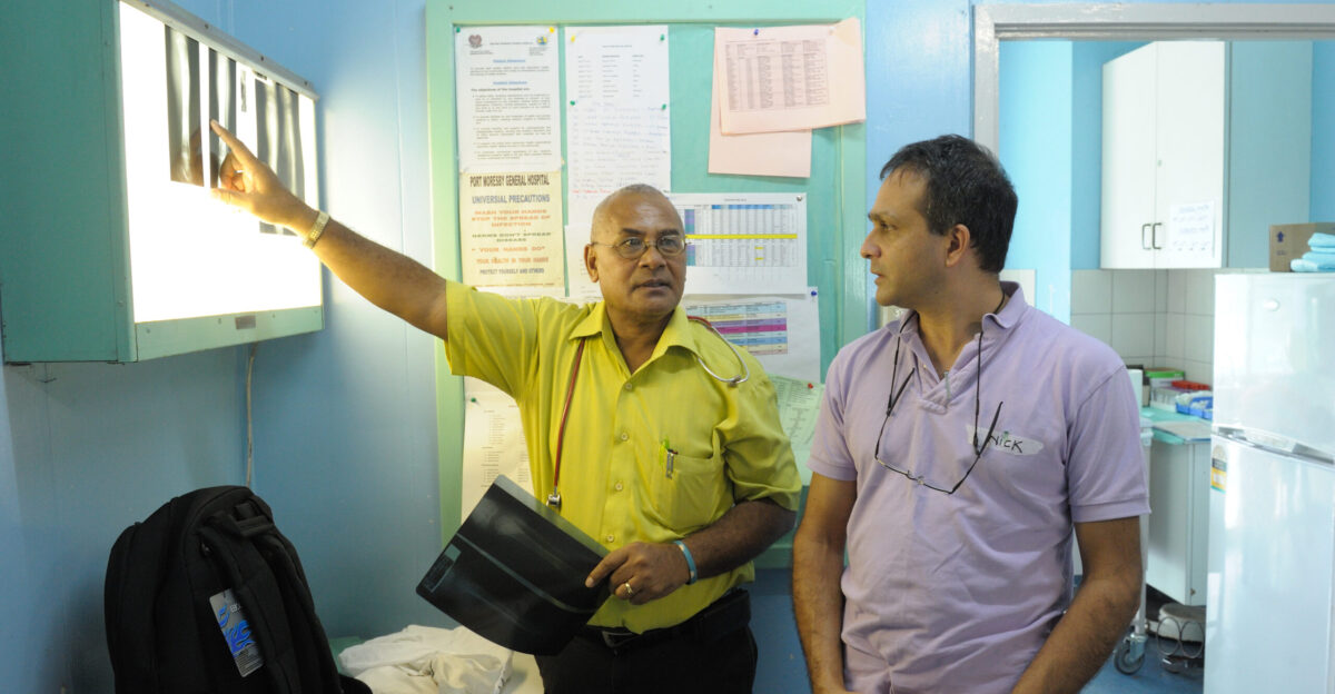 Port Moresby specilaist Associate Proffessor Nakapi Tefuarani showing Randwick specialist Dr Nick Piggot patient x-rays The two specialists worked together at Port Moresby General Hospital during Operation Open Heart an AusAID supported program where Australian surgical teams visit PNG and help train PNG teams in specialist surgery