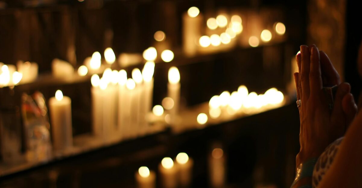 Hands clasped in prayer by candlelight in a church in S o Paulo Brazil evoking a spiritual atmosphere
