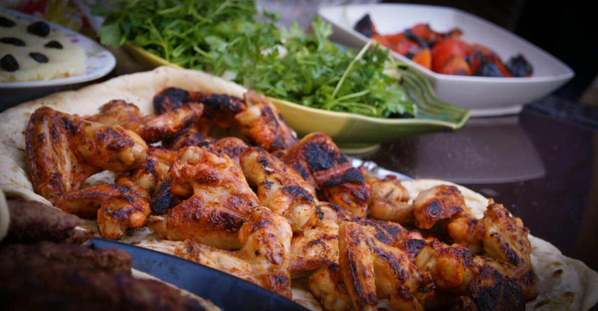 A close-up of grilled chicken wings served with fresh herbs and vegetables perfect for culinary presentations