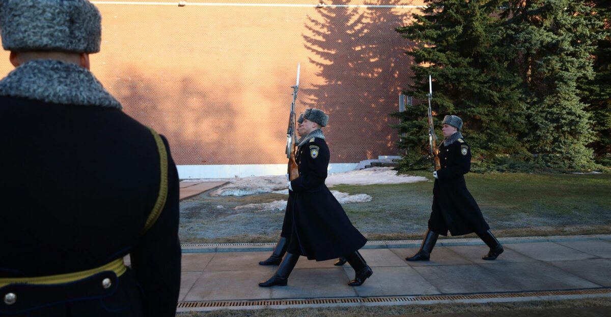 Ceremonial guards in winter uniforms march by Kremlin wall Moscow