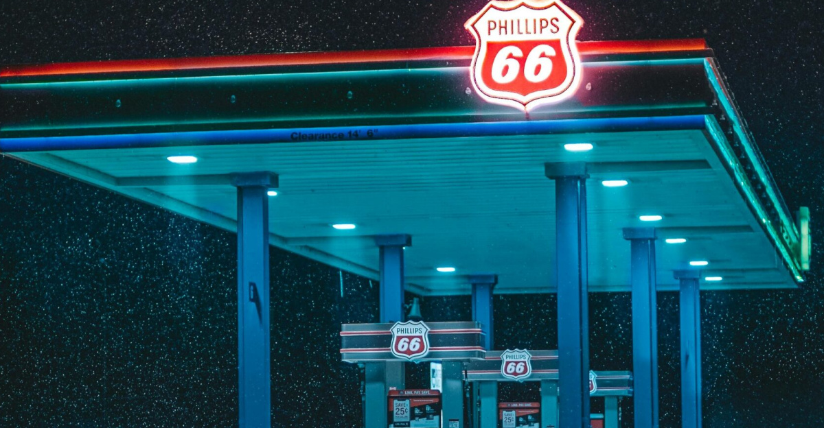A vibrant neon-lit gas station amidst a snowy landscape at night.