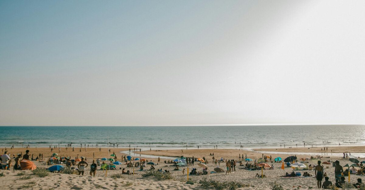 A lively beach scene with people enjoying a sunny day by the sea