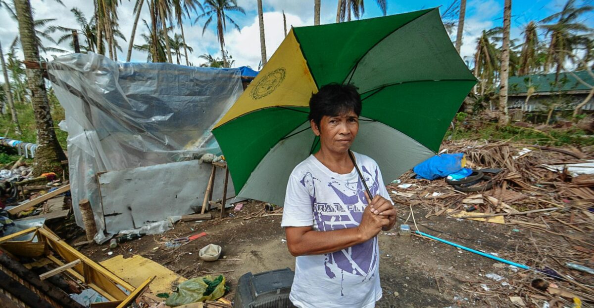 Asian woman holding an umbrella amidst storm aftermath with scattered debris