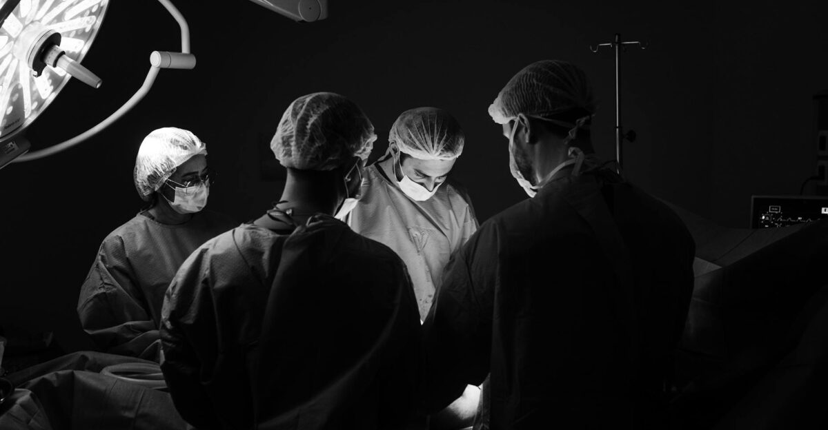 A group of surgeons in an operating room focusing intently during a procedure