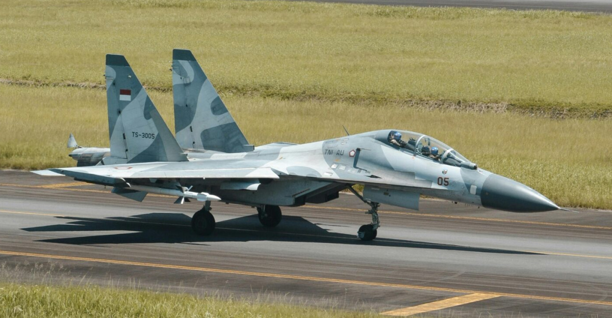Sukhoi Su-30 fighter jet on a runway with mountain backdrop in Manado, Indonesia.