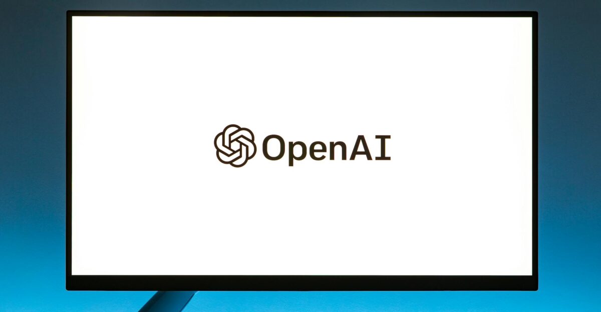 Minimalistic display of OpenAI logo on a monitor with a gradient blue background representing modern technology