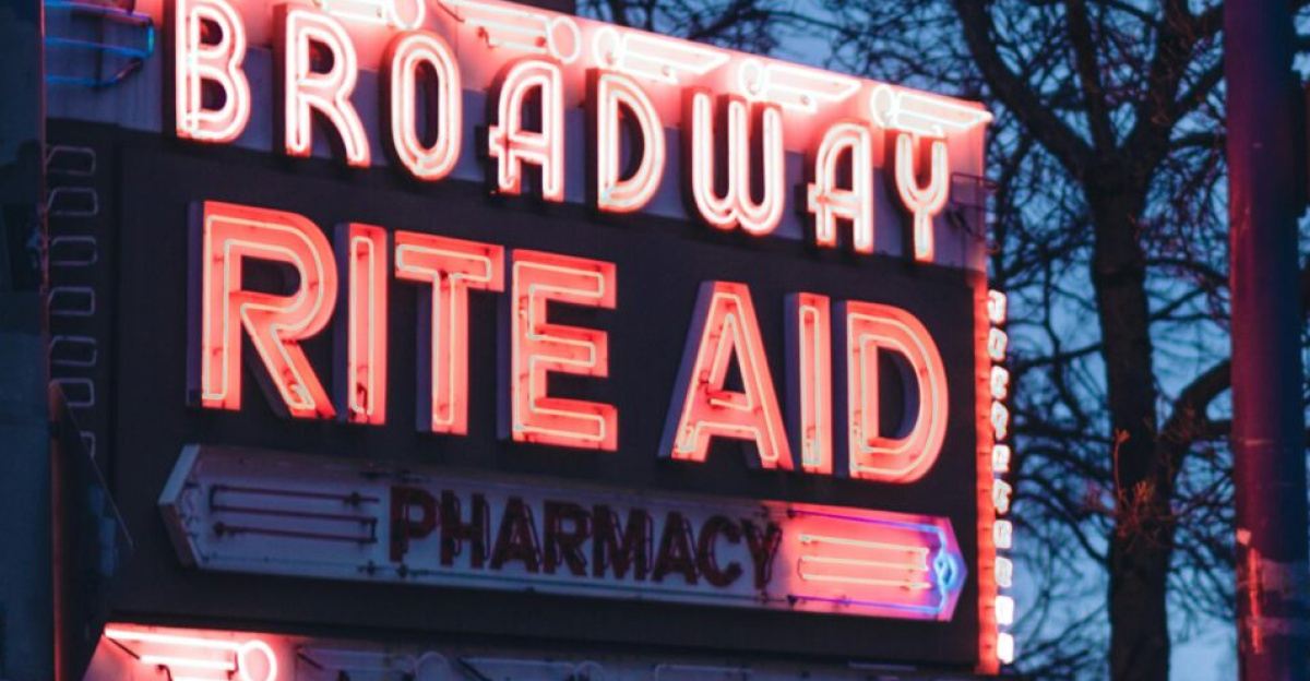 Vibrant neon signage of Broadway Rite Aid during twilight in an urban street setting.