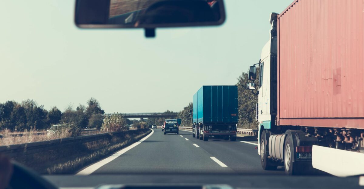 View through rearview mirror of trucks on a German highway driving towards Bamberg