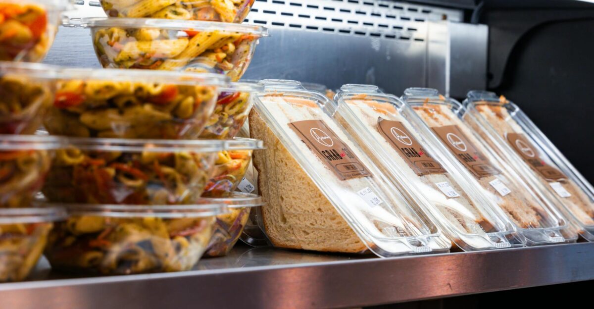 Delicious ready-to-eat pasta salads and sandwiches displayed in a store fridge