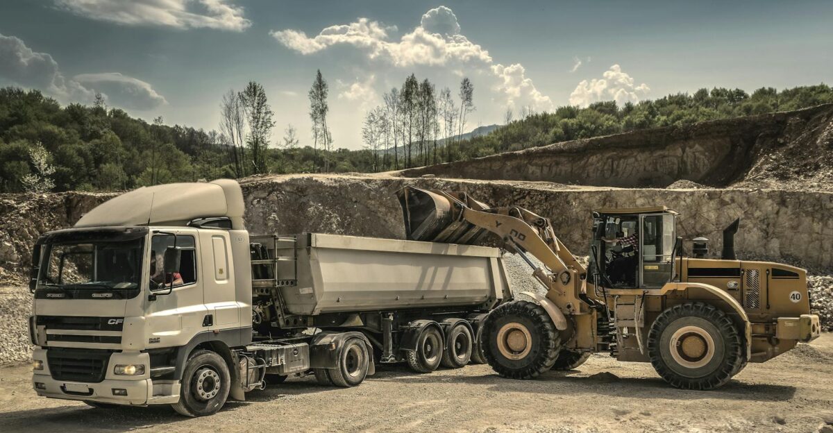 Excavator and truck working together in a quarry showcasing industrial equipment and operations