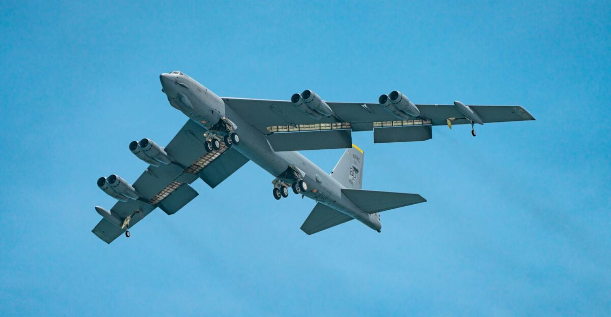 High-altitude capture of a military aircraft in flight against a blue sky