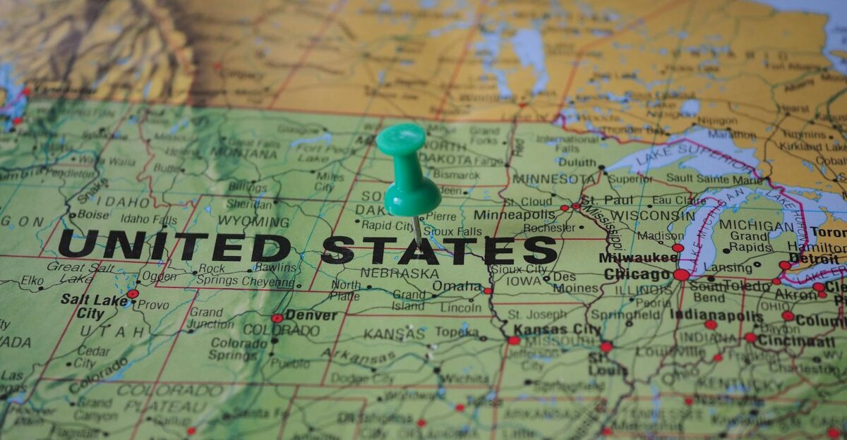 High-angle view of a map featuring the United States with a green pin indicating a specific location