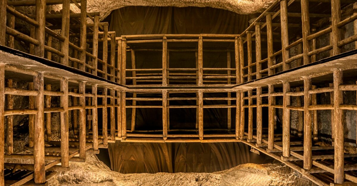 Intricate wooden scaffolding structure inside a well-lit underground cave or mine shaft