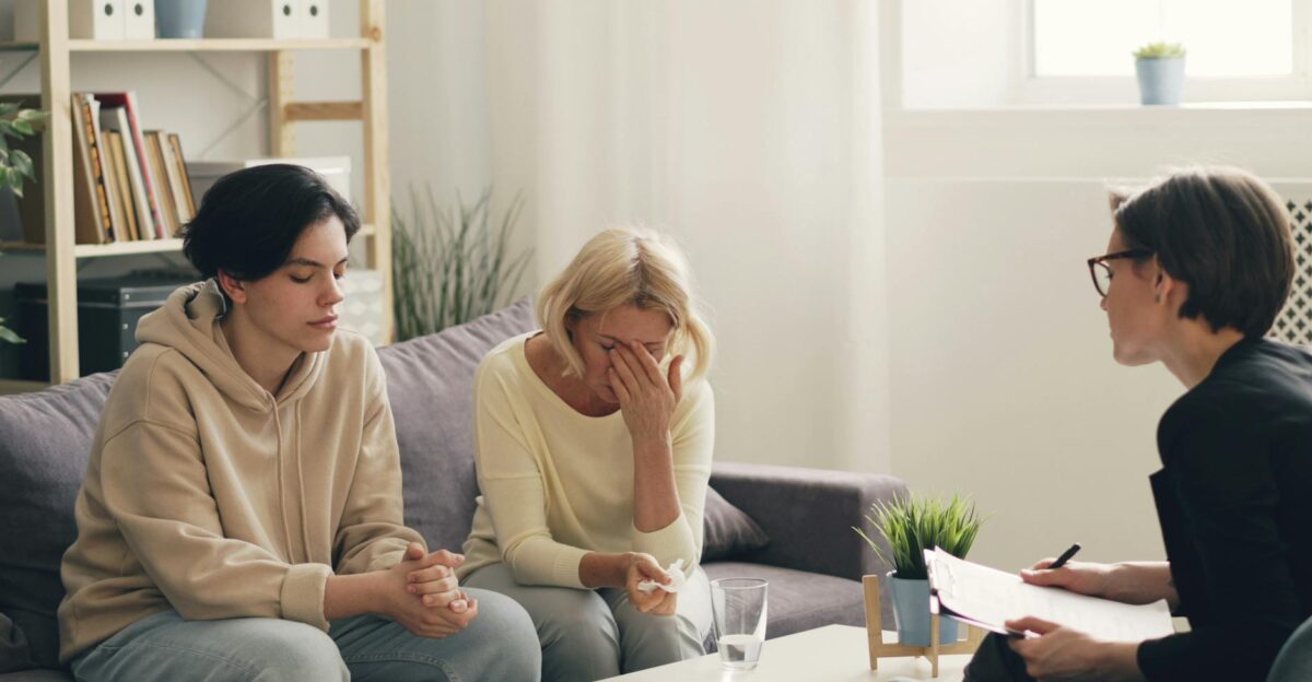 Emotional family therapy session with a therapist indoors conveying connection and support