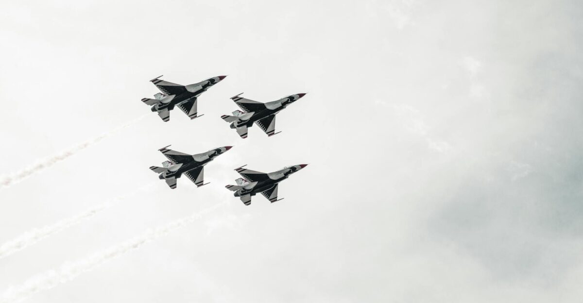 A squadron of fighter jets flying in formation against a cloudy sky