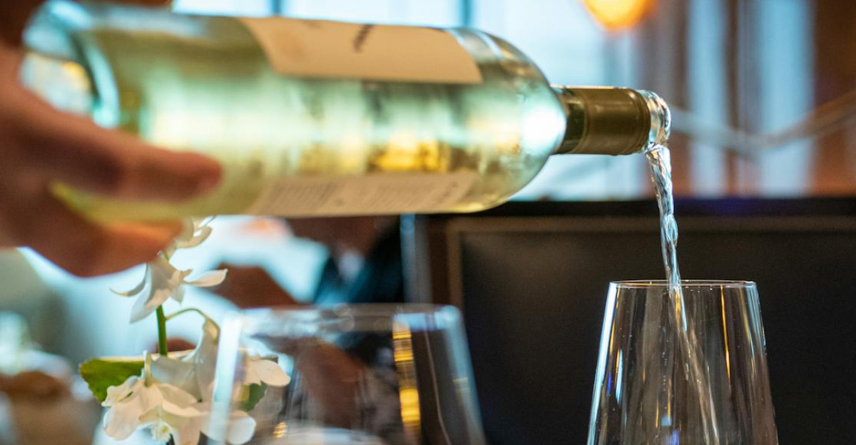 Close-up of wine being poured in a glass on a fine dining table setting