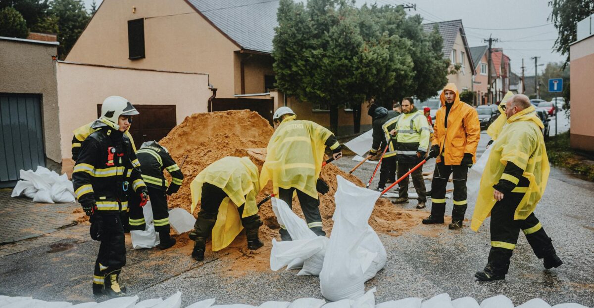 Emergency response team filling sandbags on a rainy street to prevent flooding