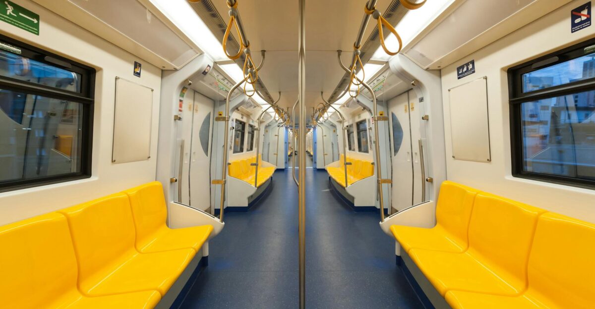 Interior of a modern subway car with bright yellow seats and clean design emphasizing public transportation