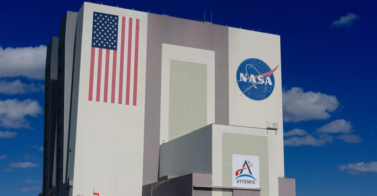 The iconic NASA Vehicle Assembly Building at Kennedy Space Center in bright daylight