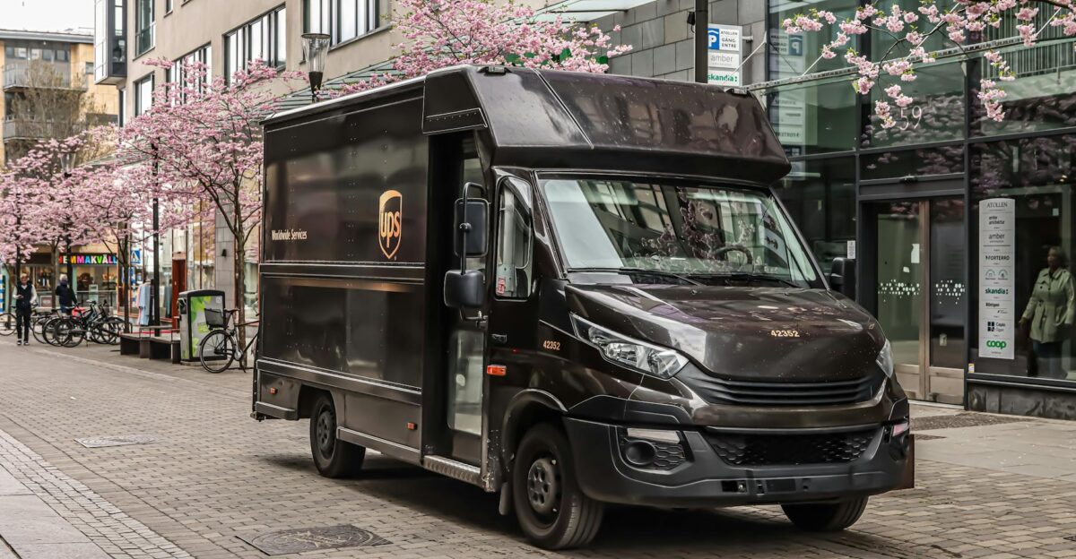 Black UPS delivery truck parked on a street in J nk ping Sweden with cherry blossoms in spring